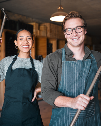 Two people holding fermentation tools