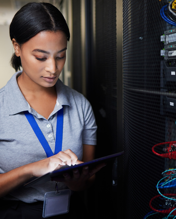 Woman looking at tablet next to server equipment