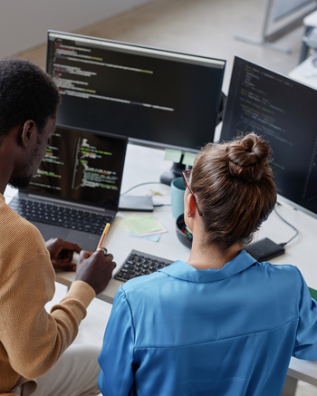 Looking down on two people working on computers together