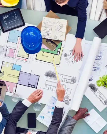 Looking down on people standing around blueprints