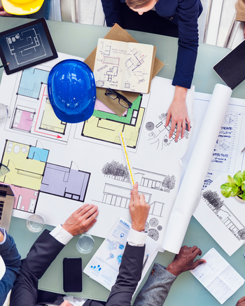 Looking down on people standing around blueprints