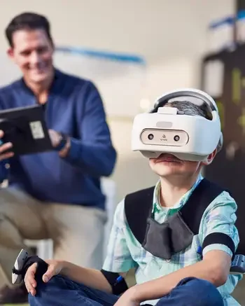 Occupational Therapist working with young boy in a virtual headset