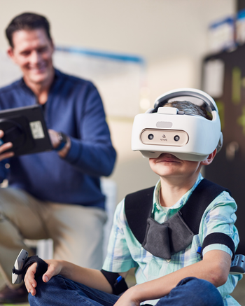 Occupational Therapist working with young boy in a virtual headset