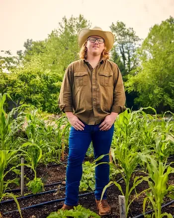 A man in a cowboy hat standing in a field