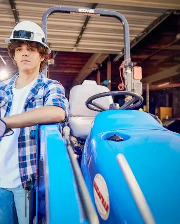 Horticulturist standing next to heavy equipment