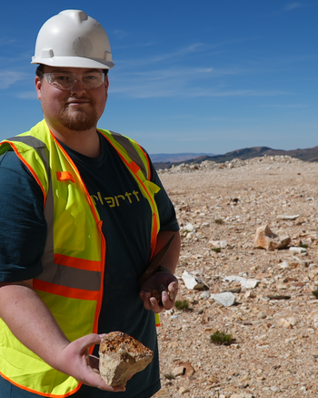 Mining Techniciah out in the field holding rocks