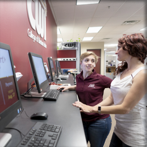 Female student talking to One Stop Student Services representative in front of a computer