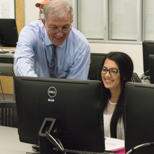 Instructor helping student at a computer station
