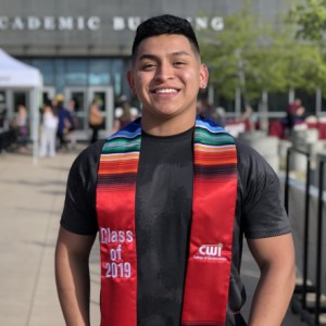 Latinx student posing with a stole. 