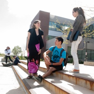 Two groups of students chatting on the stairs outside of Nampa Campus Academic Building east entrance