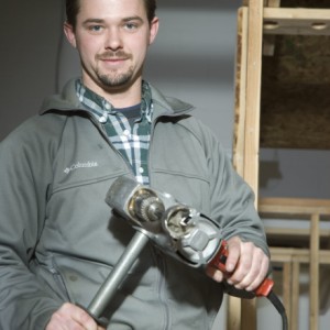 plumbing student smiling with tools