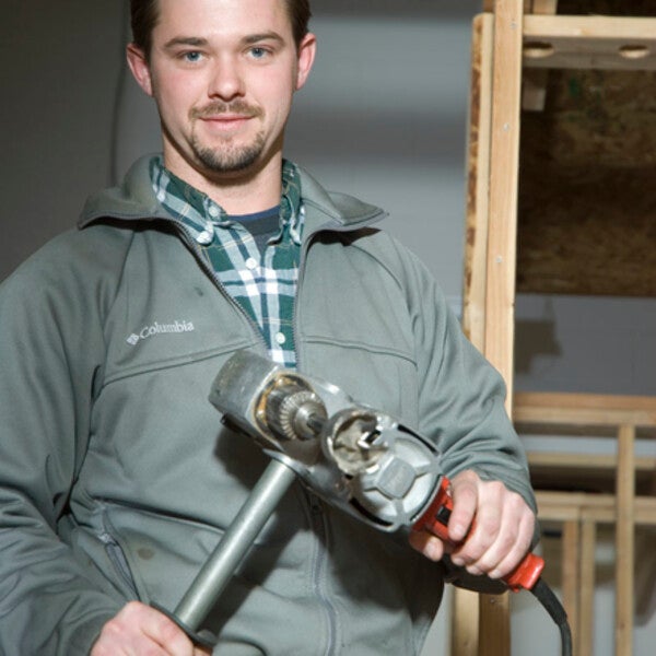 plumbing student smiling with tools