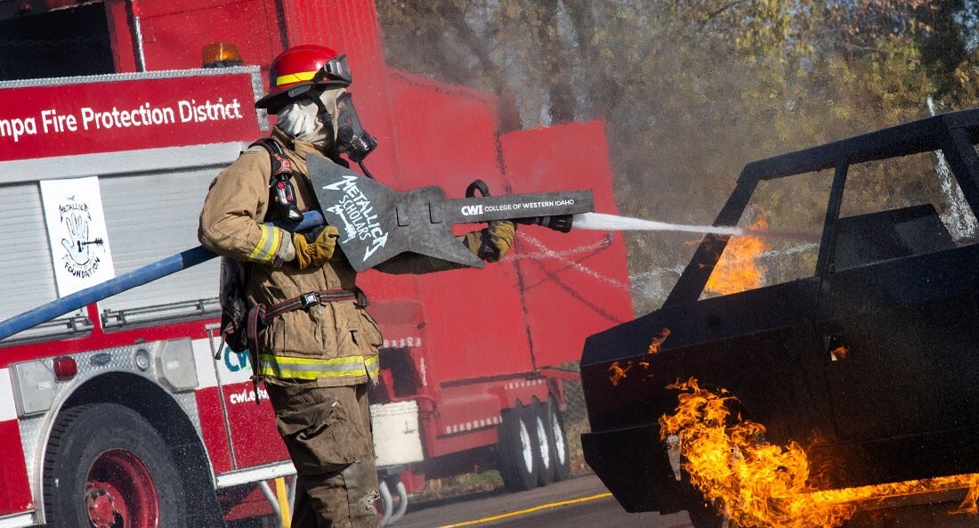 A firefighter puts out a simulated car fire.