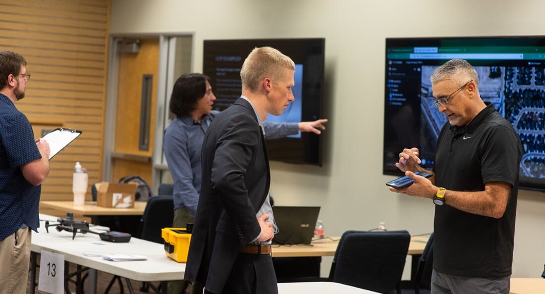 An entrepreneur shows off a product prototype to a judge.