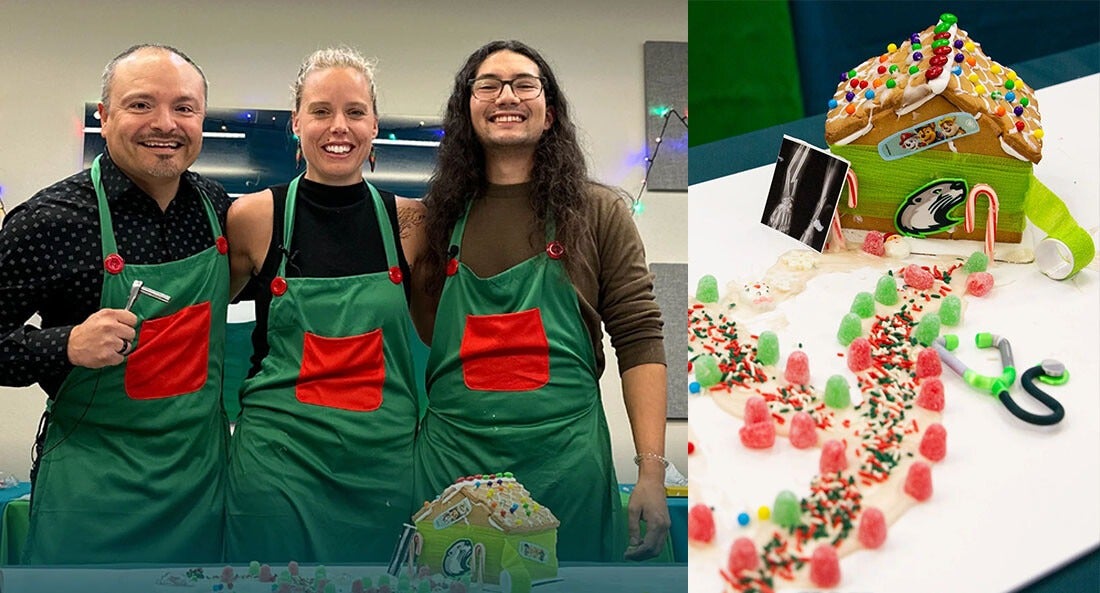 3 people pose for a photo in front a holiday ginger bread house.