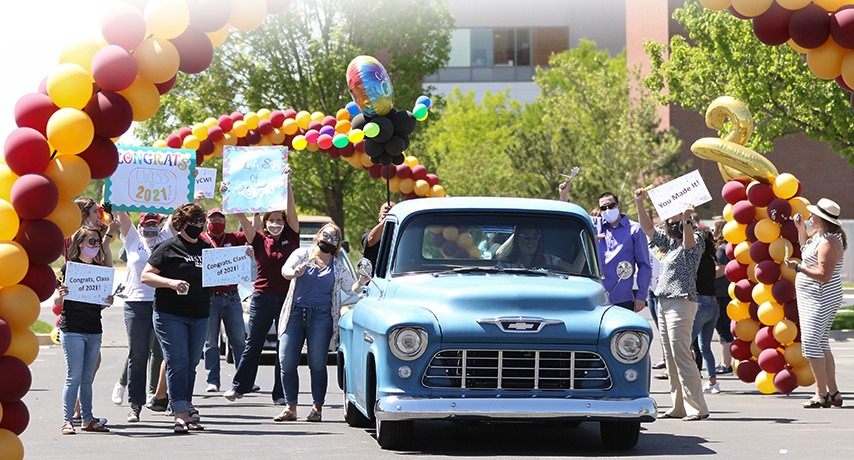 Graduate driving truck through cheering faculty and staff during Grad Fest 2021