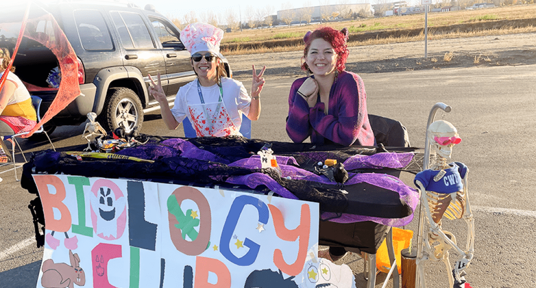 Members of the Biology Club hosting a decorated table at the CWI Trunk-or-Treat Oct. 28.