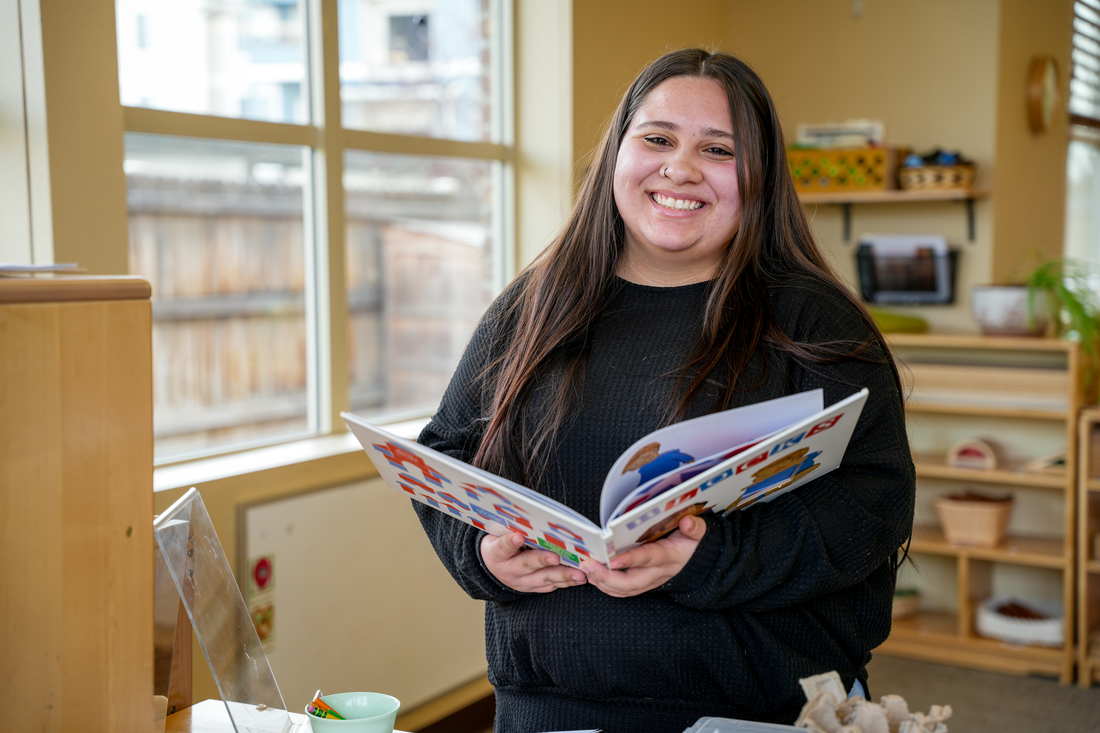 Alexus Hill reads a book in the middle of a classroom
