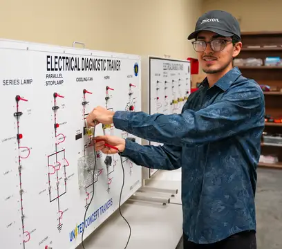 Student at board with wires 