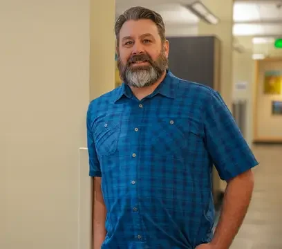 Person stands next to pillar and table
